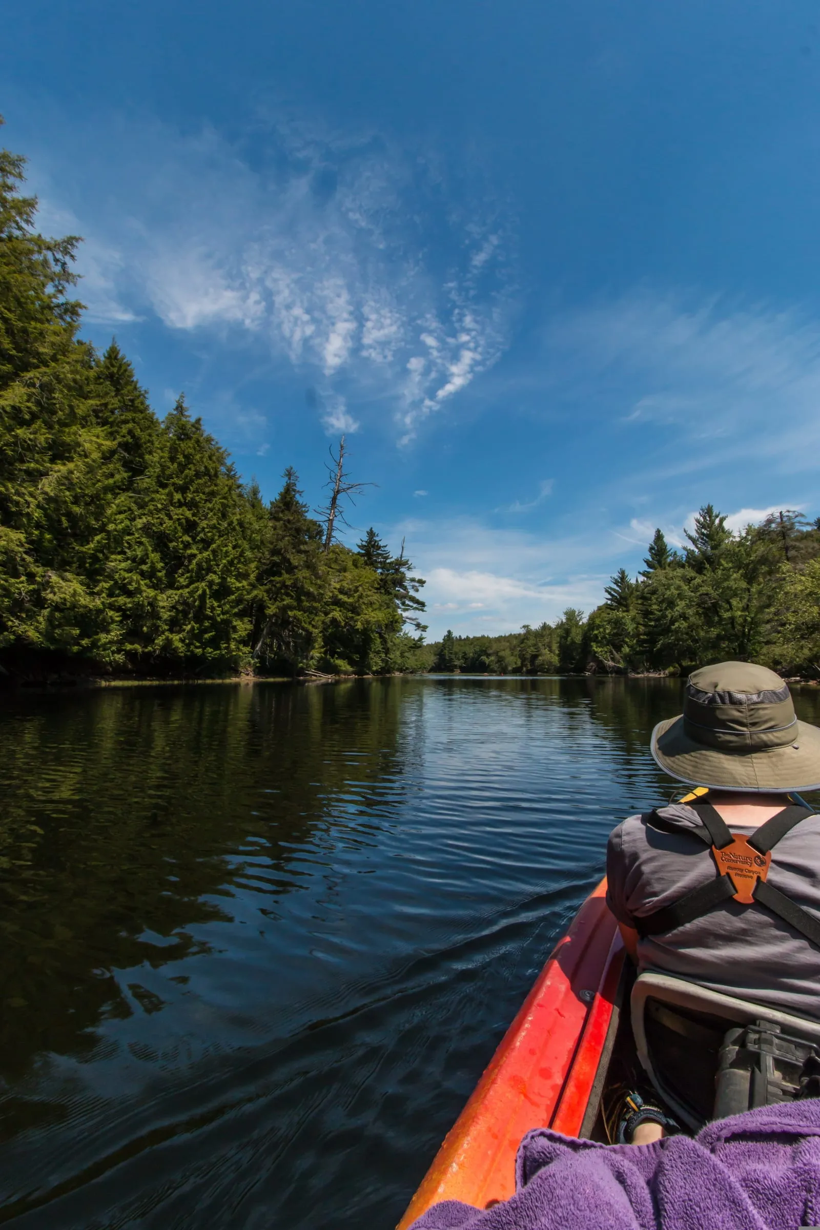 A paddler wearing a life jacket on flat, calm water